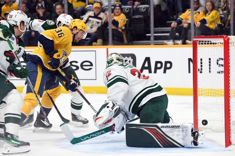 Feb 29, 2024; Nashville, Tennessee, USA; Nashville Predators left wing Cole Smith (36) scores against Minnesota Wild goaltender Filip Gustavsson (32) during the first period at Bridgestone Arena. Mandatory Credit: Christopher Hanewinckel-USA TODAY Sports