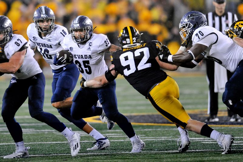 Sep 17, 2022; Iowa City, Iowa, USA; Nevada Wolf Pack running back Toa Taua (35) runs the ball against Iowa Hawkeyes defensive lineman John Waggoner (92) during the third quarter at Kinnick Stadium. Mandatory Credit: Jeffrey Becker-USA TODAY Sports