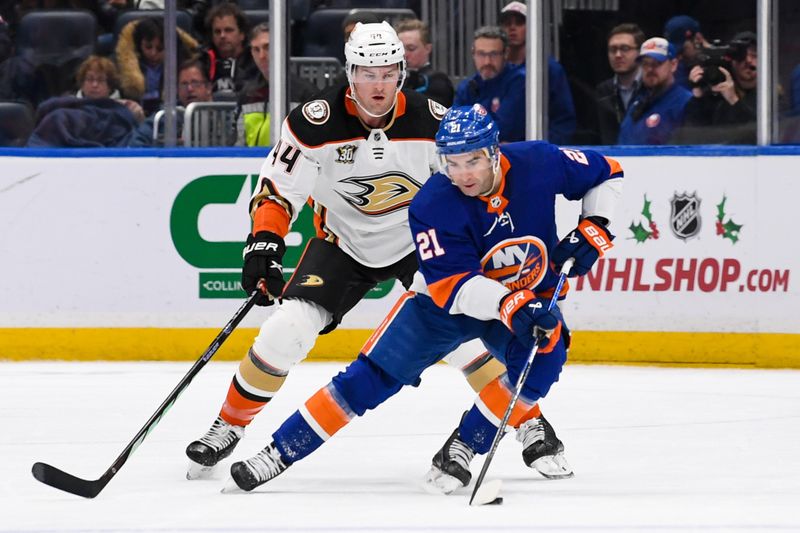 Dec 13, 2023; Elmont, New York, USA; New York Islanders center Kyle Palmieri (21) skates with the puck defended by Anaheim Ducks left wing Ross Johnston (44) during the first period at UBS Arena. Mandatory Credit: Dennis Schneidler-USA TODAY Sports