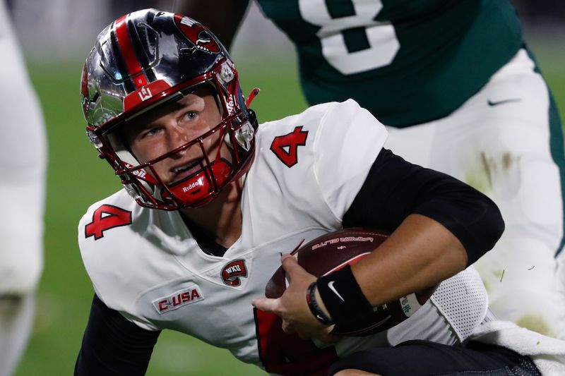 Oct 2, 2021; East Lansing, Michigan, USA; Western Kentucky Hilltoppers quarterback Bailey Zappe (4) gets up after sliding during the first quarter against the Michigan State Spartans at Spartan Stadium. Mandatory Credit: Raj Mehta-USA TODAY Sports