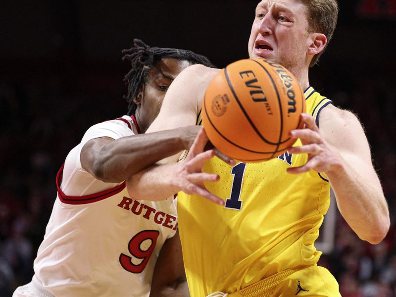 Feb 1, 2025; Piscataway, New Jersey, USA; Michigan Wolverines center Danny Wolf (1) drives to the basket as Rutgers Scarlet Knights forward Dylan Grant (9) defends during the first half at Jersey Mike's Arena. Mandatory Credit: Vincent Carchietta-Imagn Images