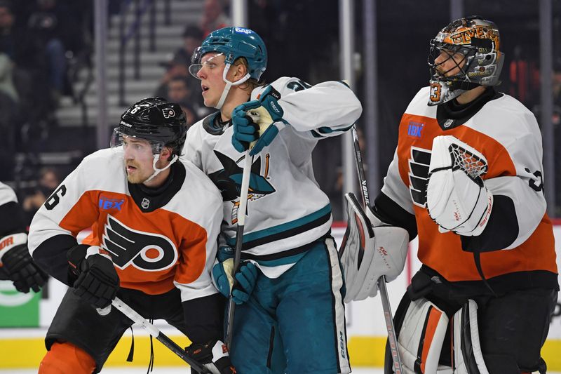 Nov 11, 2024; Philadelphia, Pennsylvania, USA; Philadelphia Flyers defenseman Travis Sanheim (6) and San Jose Sharks left wing Fabian Zetterlund (20) battle for position in front of goaltender Samuel Ersson (33) during the second period at Wells Fargo Center. Mandatory Credit: Eric Hartline-Imagn Images