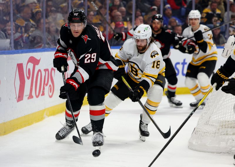 Dec 27, 2025; Buffalo, New York, USA; Buffalo Sabres left wing Beck Malenstyn (29) clears the puck from behind the net as Boston Bruins center Pavel Zacha (18) defends during the second period  at KeyBank Center. Mandatory Credit: Timothy T. Ludwig-Imagn Images