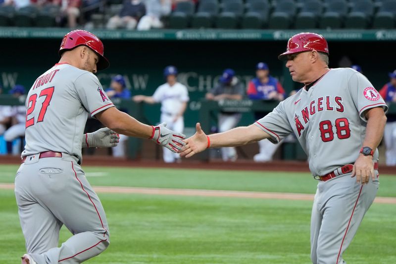 Apr 14, 2022; Arlington, Texas, USA; Los Angeles Angels center fielder Mike Trout (27) celebrates his home run with third base coach Phil Nevin (88) against the Texas Rangers during the first inning of a baseball game at Globe Life Field. Mandatory Credit: Jim Cowsert-USA TODAY Sports