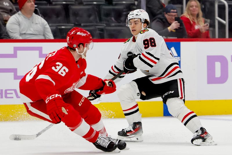 Nov 30, 2023; Detroit, Michigan, USA; Chicago Blackhawks center Connor Bedard (98) skates with the puck defended by Detroit Red Wings right wing Christian Fischer (36) in the third period at Little Caesars Arena. Mandatory Credit: Rick Osentoski-USA TODAY Sports