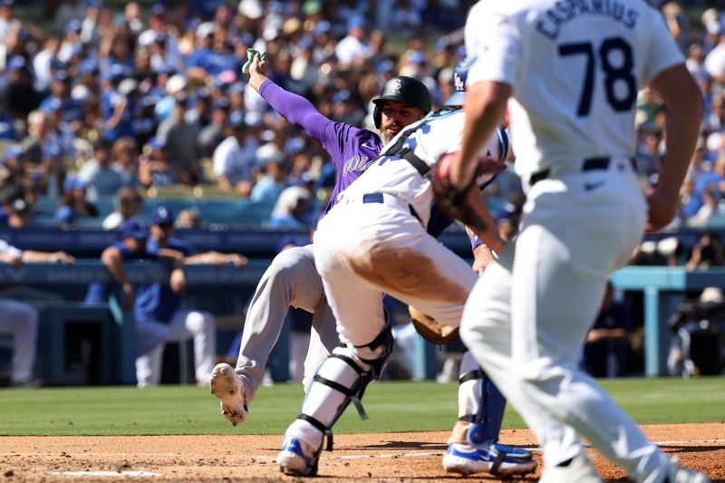 Sep 22, 2024; Los Angeles, California, USA;  Colorado Rockies right fielder Jake Cave (11) slides in safe at home while Los Angeles Dodgers catcher Will Smith (16) awaits the throw during the sixth inning at Dodger Stadium. Mandatory Credit: Kiyoshi Mio-Imagn Images