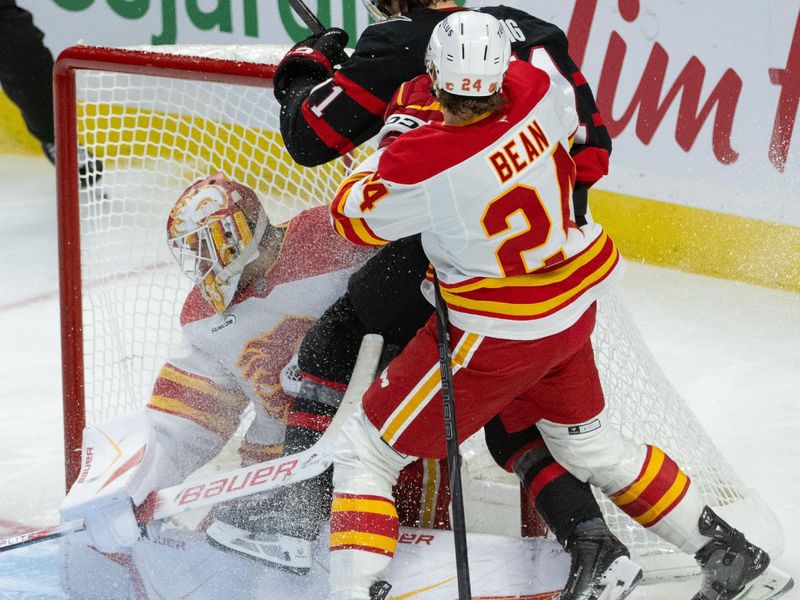 Oct 30, 2025; Ottawa, Ontario, CAN; Ottawa Senators center Ridly Greig (71) is checked into the goal by Calgary Flames defenseman Jake Bean (24) in the third period at the Canadian Tire Centre. Mandatory Credit: Marc DesRosiers-IMAGN Images
