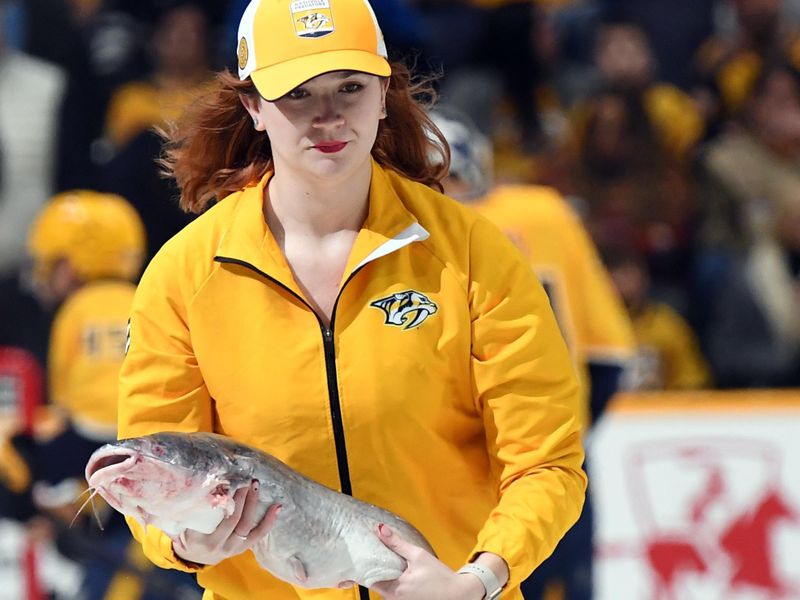 Feb 10, 2024; Nashville, Tennessee, USA; A member of the Nashville Predators ice crew removes a catfish from the ice before the game against the Arizona Coyotes at Bridgestone Arena. Mandatory Credit: Christopher Hanewinckel-USA TODAY Sports