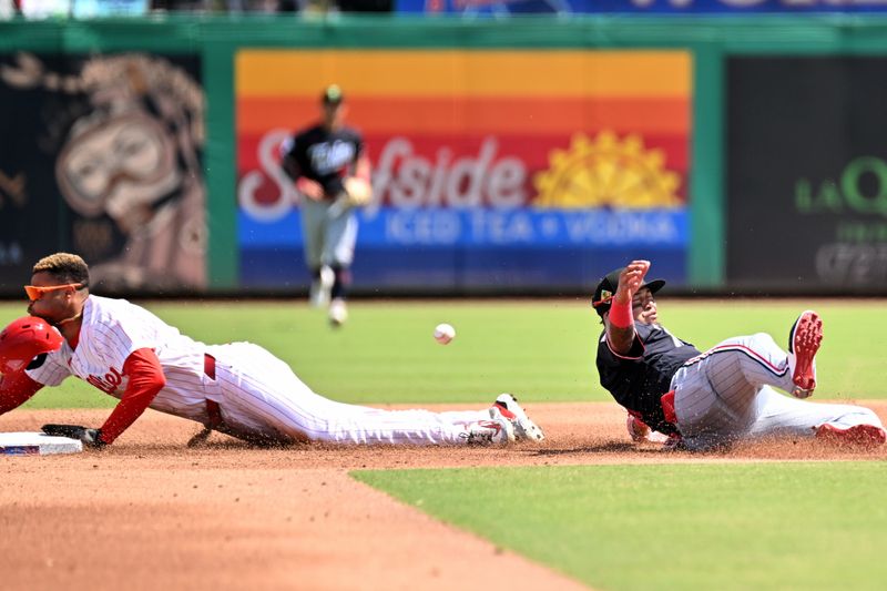 Mar 17, 2026; Clearwater, Florida, USA; The ball gets past Minnesota Twins second baseman Orlando Arcia (11) as Philadelphia Phillies center fielder Justin Crawford (80) slides in the third inning  during spring training  at BayCare Ballpark. Mandatory Credit: Jonathan Dyer-Imagn Images