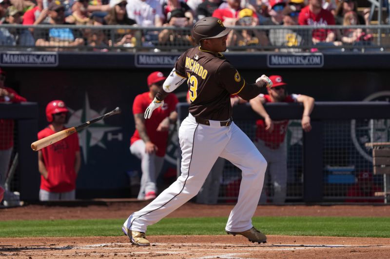 Mar 22, 2025; Peoria, Arizona, USA; San Diego Padres third base Manny Machado (13) hits a single against the Cincinnati Reds in the first inning at Peoria Sports Complex. Mandatory Credit: Rick Scuteri-Imagn Images