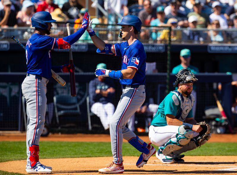 Mar 5, 2024; Peoria, Arizona, USA; Texas Rangers outfielder Evan Carter (right) celebrates with Leody Taveras after hitting a home run against the Seattle Mariners during a spring training baseball game at Peoria Sports Complex. Mandatory Credit: Mark J. Rebilas-USA TODAY Sports