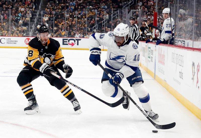 Apr 6, 2024; Pittsburgh, Pennsylvania, USA;  Tampa Bay Lightning left wing Anthony Duclair (10) moves the puck against Pittsburgh Penguins left wing Michael Bunting (8) during the second period at PPG Paints Arena. Mandatory Credit: Charles LeClaire-USA TODAY Sports