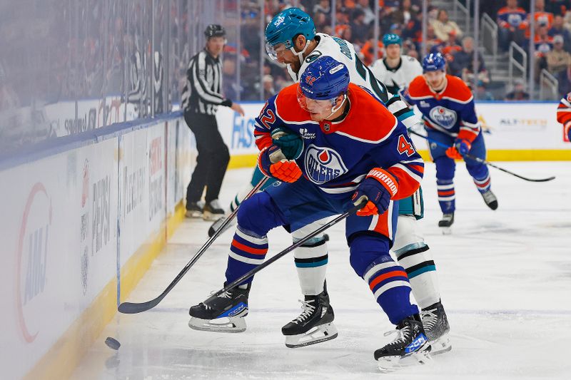 Jan 29, 2026; Edmonton, Alberta, CAN; Edmonton Oilers defensemen Ty Emberson (49) and San Jose Sharks forward Barclay Goodrow (23) battle along the boards for a loose puck during the second period at Rogers Place. Mandatory Credit: Perry Nelson-Imagn Images