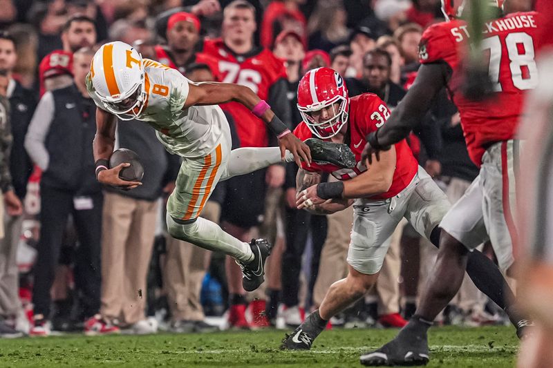 Nov 16, 2024; Athens, Georgia, USA; Tennessee Volunteers quarterback Nico Iamaleava (8) is upended by Georgia Bulldogs linebacker Chaz Chambliss (32) during the second half at Sanford Stadium. Mandatory Credit: Dale Zanine-Imagn Images