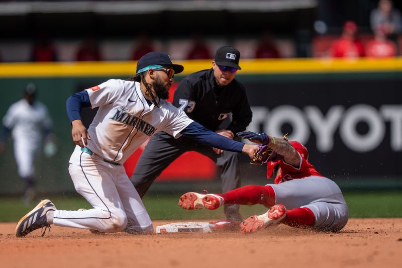 Apr 30, 2025; Seattle, Washington, USA;  Seattle Mariners shortstop J.P. Crawford (3) tags out Los Angeles Angels shortstop Zach Neto (9) trying to steal second base during the sixth inning at T-Mobile Park. Mandatory Credit: Stephen Brashear-Imagn Images