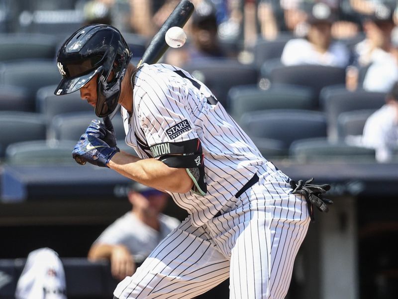Aug 25, 2024; Bronx, New York, USA;  New York Yankees designated hitter Giancarlo Stanton (27) is hit by a pitch in the third inning against the Colorado Rockies at Yankee Stadium. Mandatory Credit: Wendell Cruz-USA TODAY Sports