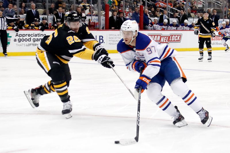 Feb 23, 2023; Pittsburgh, Pennsylvania, USA; Edmonton Oilers center Connor McDavid (97) skates with the puck around Pittsburgh Penguins defenseman Jeff Petry (26) during the third period at PPG Paints Arena. Edmonton won 7-2. Mandatory Credit: Charles LeClaire-USA TODAY Sports