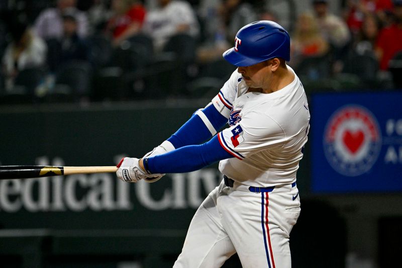 Apr 23, 2024; Arlington, Texas, USA; Texas Rangers first baseman Nathaniel Lowe (30) hits a single against the Seattle Mariners during the game at Globe Life Field. Mandatory Credit: Jerome Miron-USA TODAY Sports