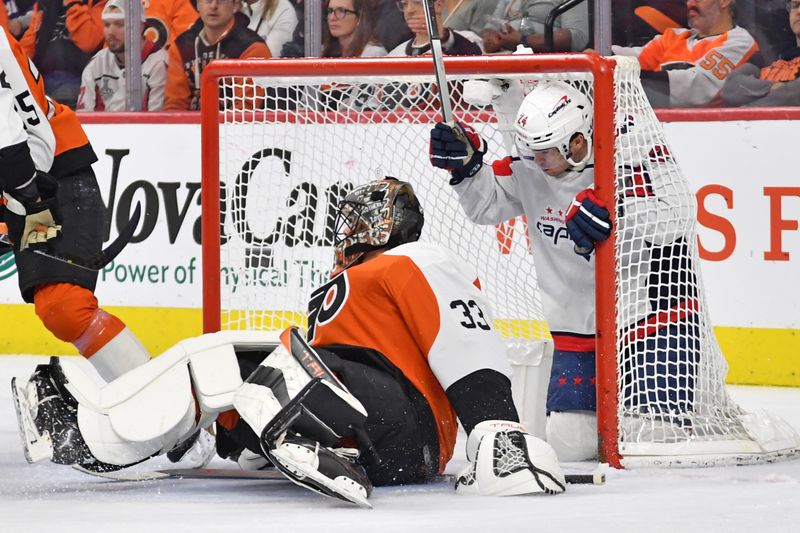 Apr 16, 2024; Philadelphia, Pennsylvania, USA; Washington Capitals center Connor McMichael (24) ends up in the goal with Philadelphia Flyers goaltender Samuel Ersson (33) during the first period at Wells Fargo Center. Mandatory Credit: Eric Hartline-USA TODAY Sports