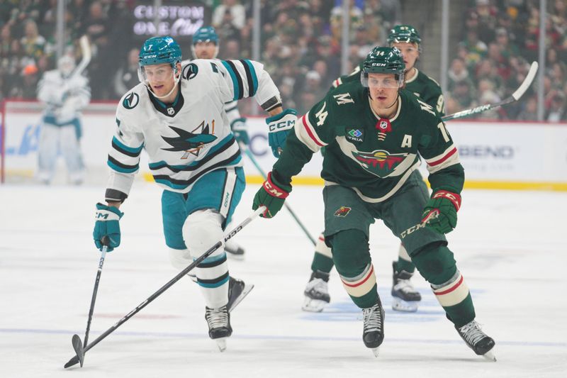 Mar 3, 2024; Saint Paul, Minnesota, USA; San Jose Sharks center Nico Sturm (7) and Minnesota Wild center Joel Eriksson Ek (14) chase a loose puck in the first period at Xcel Energy Center. Mandatory Credit: Matt Blewett-USA TODAY Sports