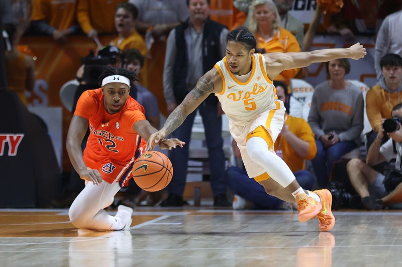 Feb 28, 2024; Knoxville, Tennessee, USA; Auburn Tigers guard Denver Jones (12) and Tennessee Volunteers guard Zakai Zeigler (5) scramble for a loose ball during the first half at Thompson-Boling Arena at Food City Center. Mandatory Credit: Randy Sartin-USA TODAY Sports