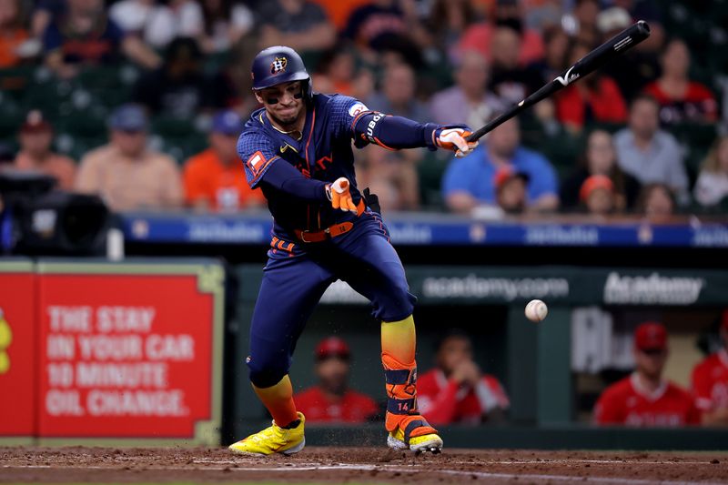 May 20, 2024; Houston, Texas, USA; Houston Astros left fielder Mauricio Dubon (14) hits an infield single against the Los Angeles Angels during the second inning at Minute Maid Park. Mandatory Credit: Erik Williams-USA TODAY Sports