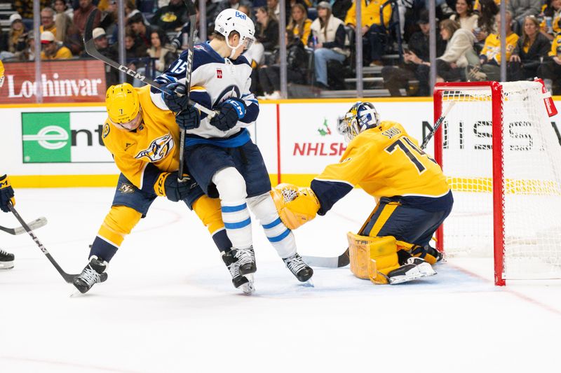 Nov 23, 2024; Nashville, Tennessee, USA;  Nashville Predators goaltender Juuse Saros (74) blocks the deflection Winnipeg Jets center Rasmus Kupari (15) during the second period at Bridgestone Arena. Mandatory Credit: Steve Roberts-Imagn Images