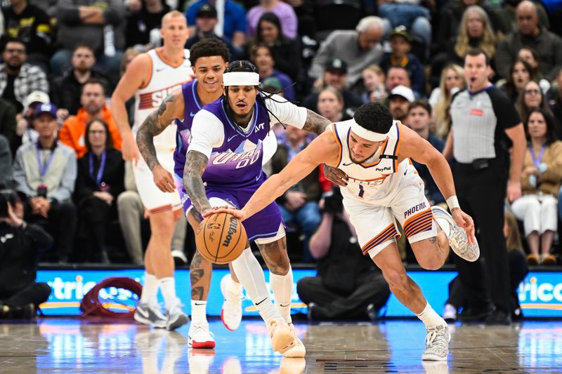 SALT LAKE CITY, UTAH - DECEMBER 13: Jordan Clarkson #00 of the Utah Jazz and Devin Booker #1 of the Phoenix Suns race to the ball during the first half of a game at Delta Center on December 13, 2024 in Salt Lake City, Utah.  NOTE TO USER: User expressly acknowledges and agrees that, by downloading and or using this photograph, User is consenting to the terms and conditions of the Getty Images License Agreement. (Photo by Alex Goodlett/Getty Images)