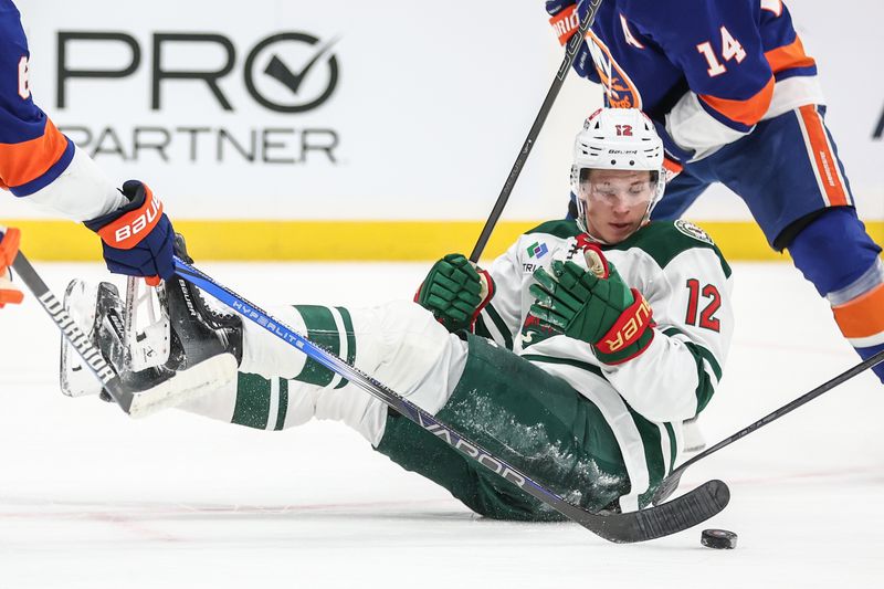 Apr 4, 2025; Elmont, New York, USA;  Minnesota Wild left wing Matt Boldy (12) chases the puck after falling down in the third period against the New York Islanders at UBS Arena. Mandatory Credit: Wendell Cruz-Imagn Images
