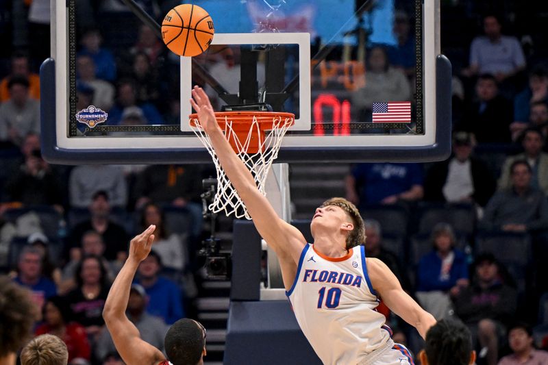 Mar 15, 2025; Nashville, TN, USA;  Florida Gators forward Thomas Haugh (10) blocks the shot of  Alabama Crimson Tide guard Latrell Wrightsell Jr. (3) during the second half at Bridgestone Arena. Mandatory Credit: Steve Roberts-Imagn Images