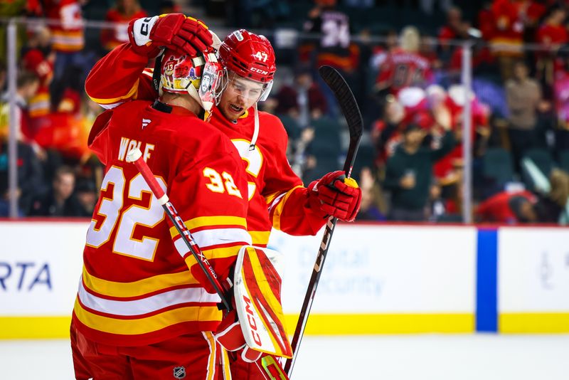 Nov 11, 2024; Calgary, Alberta, CAN; Calgary Flames goaltender Dustin Wolf (32) and center Connor Zary (47) celebrate after defeating Los Angeles Kings at Scotiabank Saddledome. Mandatory Credit: Sergei Belski-Imagn Images