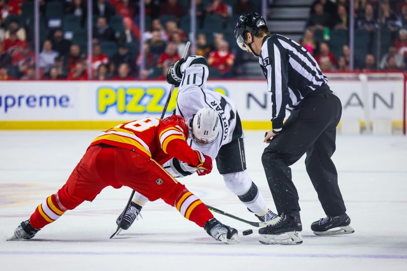 Mar 28, 2023; Calgary, Alberta, CAN; Los Angeles Kings center Anze Kopitar (11) and Calgary Flames center Elias Lindholm (28) face off for the puck during the third period at Scotiabank Saddledome. Mandatory Credit: Sergei Belski-USA TODAY Sports