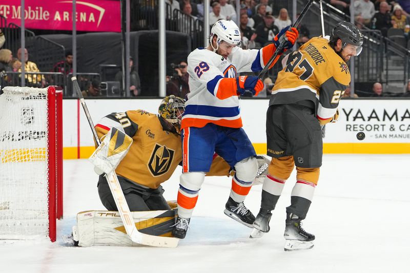 Nov 13, 2025; Las Vegas, Nevada, USA; Vegas Golden Knights defenseman Shea Theodore (27) blocks a shot as New York Islanders left wing Jonathan Drouin (29) attempts to screen Vegas Golden Knights goaltender Akira Schmid (40) during the second period at T-Mobile Arena. Mandatory Credit: Stephen R. Sylvanie-Imagn Images