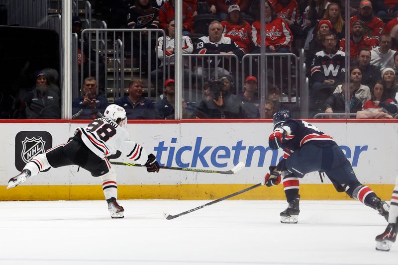 Mar 9, 2024; Washington, District of Columbia, USA; Chicago Blackhawks center Connor Bedard (98) shoots the puck as Washington Capitals left wing Beck Malenstyn (47) defends in the third period at Capital One Arena. Mandatory Credit: Geoff Burke-USA TODAY Sports