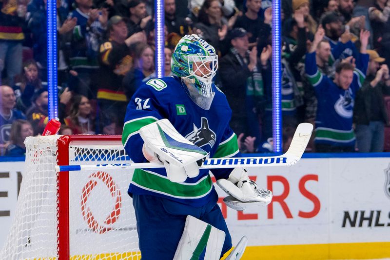 Nov 12, 2024; Vancouver, British Columbia, CAN; Vancouver Canucks goalie Kevin Lankinen (32) celebrates a victory against the Calgary Flames at Rogers Arena. Mandatory Credit: Bob Frid-Imagn Images