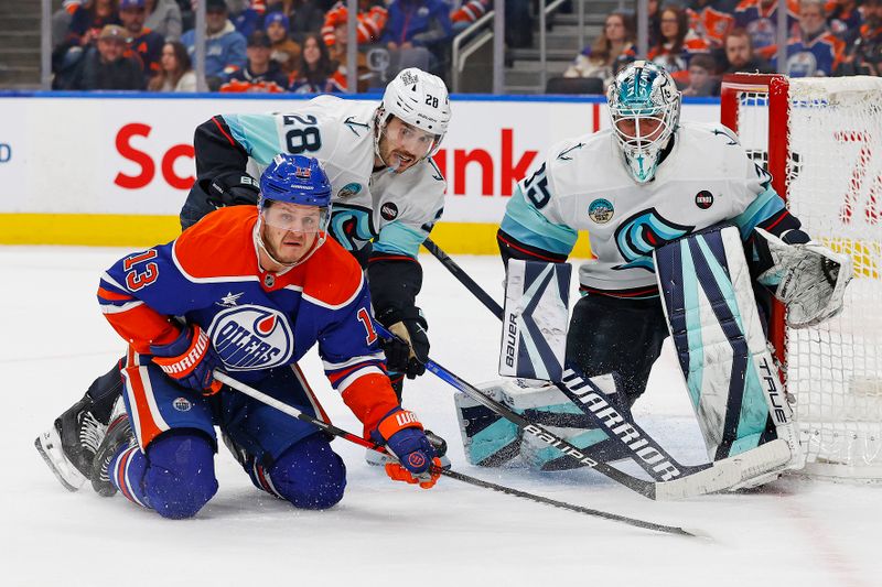 Jan 27, 2025; Edmonton, Alberta, CAN; Seattle Kraken defensemen Josh Mahura (28) knocks down Edmonton Oilers forward Mattias Janmark (13) in front of Seattle Kraken goaltender Joey Daccord (35) during the first period at Rogers Place. Mandatory Credit: Perry Nelson-Imagn Images