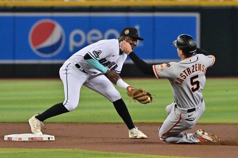 Sep 20, 2023; Phoenix, Arizona, USA;  San Francisco Giants center fielder Mike Yastrzemski (5) is tagged out by Arizona Diamondbacks shortstop Geraldo Perdomo (2) in the first inning at Chase Field. Mandatory Credit: Matt Kartozian-USA TODAY Sports