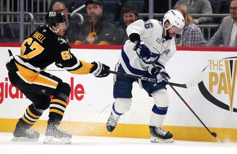 Nov 19, 2024; Pittsburgh, Pennsylvania, USA;  Tampa Bay Lightning right wing Nikita Kucherov (86) moves the puck against Pittsburgh Penguins right wing Rickard Rakell (67) during the first period at PPG Paints Arena. Mandatory Credit: Charles LeClaire-Imagn Images