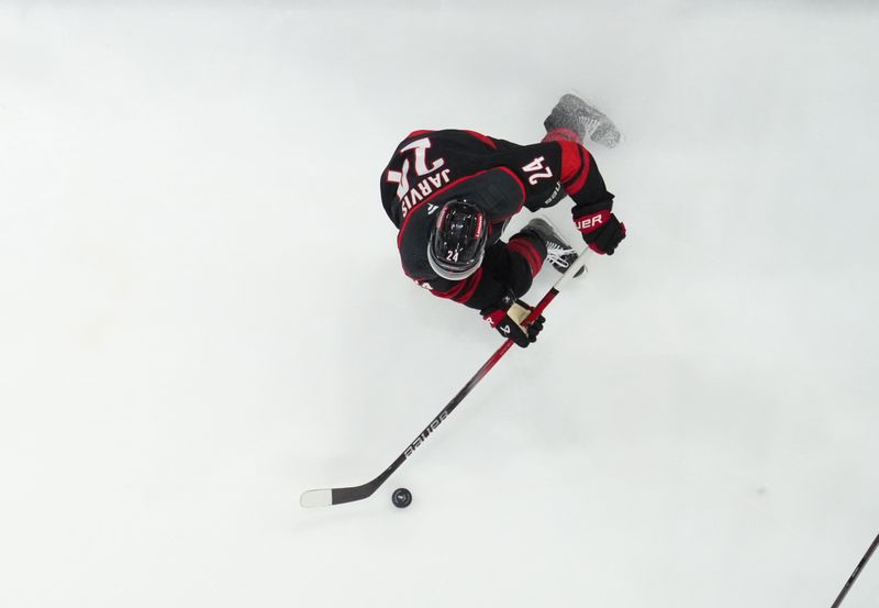 May 12, 2025; Raleigh, North Carolina, USA; Carolina Hurricanes center Seth Jarvis (24) skates with the puck against the Washington Capitals during the third period in game four of the second round of the 2025 Stanley Cup Playoffs at Lenovo Center. Mandatory Credit: James Guillory-Imagn Images