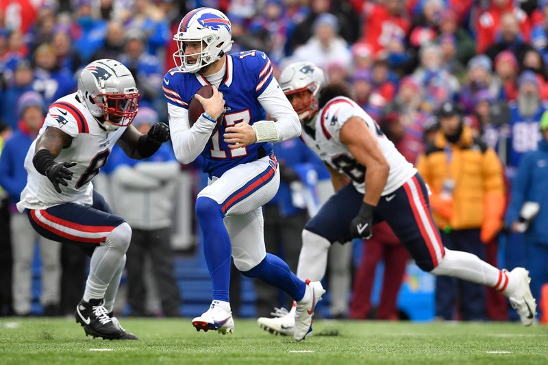 Buffalo Bills quarterback Josh Allen (17) runs with the ball against New England Patriots linebacker Ja'Whaun Bentley (8) during the first half of an NFL football game in Orchard Park, N.Y., Sunday, Dec. 31, 2023. (AP Photo/Adrian Kraus)