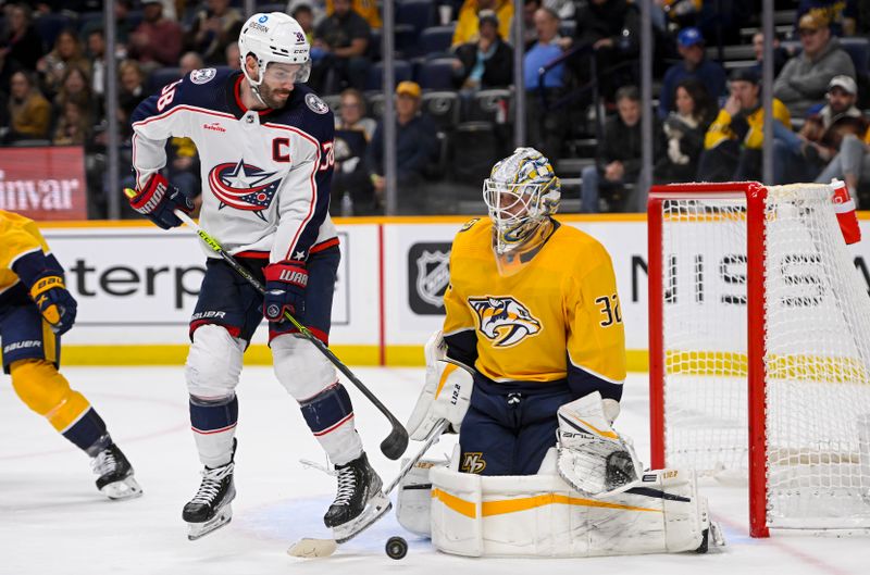 Jan 17, 2023; Nashville, Tennessee, USA;  Nashville Predators goaltender Kevin Lankinen (32) blocks the deflection of Columbus Blue Jackets center Boone Jenner (38) during the second period at Bridgestone Arena. Mandatory Credit: Steve Roberts-USA TODAY Sports