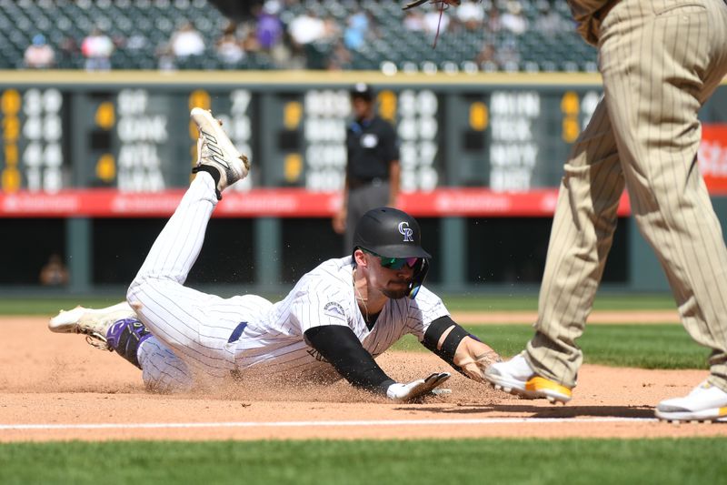 Aug 18, 2024; Denver, Colorado, USA; Colorado Rockies outfielder Brenton Doyle (9) slides into third base after hitting a triple in the sixth inning against the San Diego Padres at Coors Field. Mandatory Credit: Christopher Hanewinckel-USA TODAY Sports