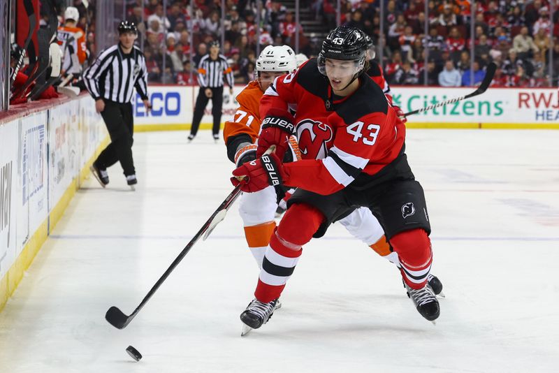 Dec 19, 2023; Newark, New Jersey, USA; New Jersey Devils defenseman Luke Hughes (43) plays the puck while being defended by Philadelphia Flyers right wing Tyson Foerster (71) during the first period at Prudential Center. Mandatory Credit: Ed Mulholland-USA TODAY Sports