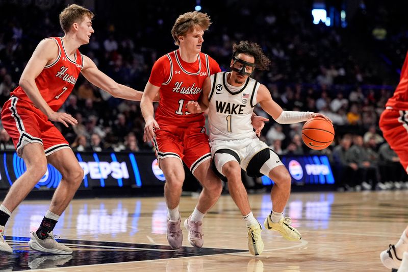 Nov 28, 2025; Winston-Salem, North Carolina, USA; Wake Forest Demon Deacons guard Nate Calmese (1) handles the ball against Northeastern Huskies guard Luca Soroa Schaller (13) during the first half at Lawrence Joel Veterans Memorial Coliseum. Mandatory Credit: Jim Dedmon-Imagn Images