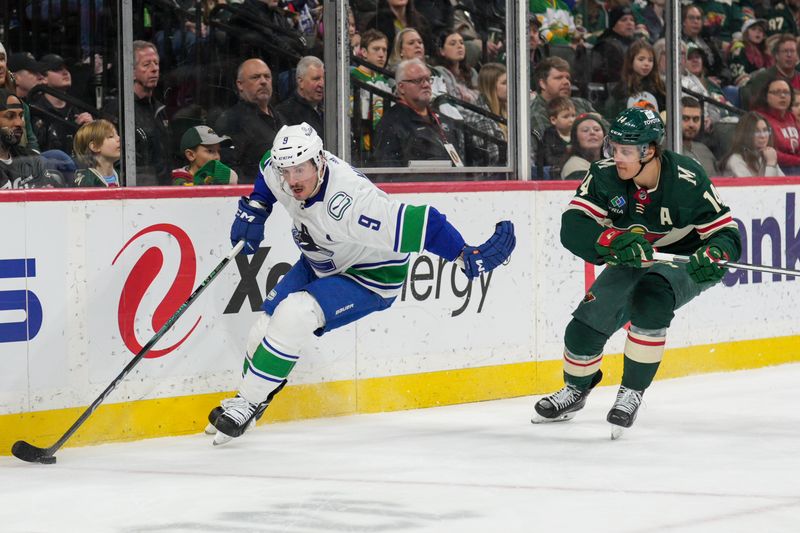 Feb 19, 2024; Saint Paul, Minnesota, USA; Vancouver Canucks center J.T. Miller (9) is pursued by Minnesota Wild center Joel Eriksson Ek (14) behind the Wild net in the first period at Xcel Energy Center. Mandatory Credit: Matt Blewett-USA TODAY Sports