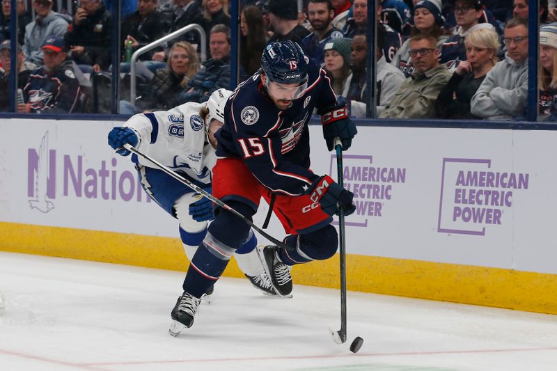 Nov 21, 2024; Columbus, Ohio, USA; Columbus Blue Jackets defenseman Dante Fabbro (15) picks up a loose puck as Tampa Bay Lightning left wing Brandon Hagel (38) trails the play during the first period at Nationwide Arena. Mandatory Credit: Russell LaBounty-Imagn Images