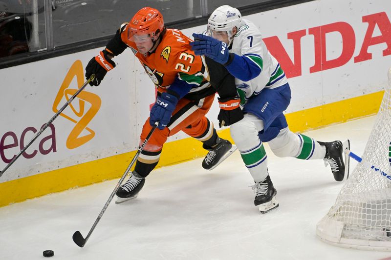 Nov 5, 2024; Anaheim, California, USA; Anaheim Ducks center Mason McTavish (23) and Vancouver Canucks defenseman Carson Soucy (7) chase down the puck battle in the second period at Honda Center. Mandatory Credit: Jayne Kamin-Oncea-Imagn Images