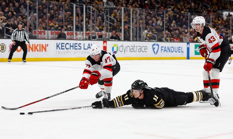 Jan 15, 2024; Boston, Massachusetts, USA; Boston Bruins center Trent Frederic (11) dives to poke a loose puck into the empty net past New Jersey Devils defenseman Simon Nemec (17) during the third period at TD Garden. Mandatory Credit: Winslow Townson-USA TODAY Sports