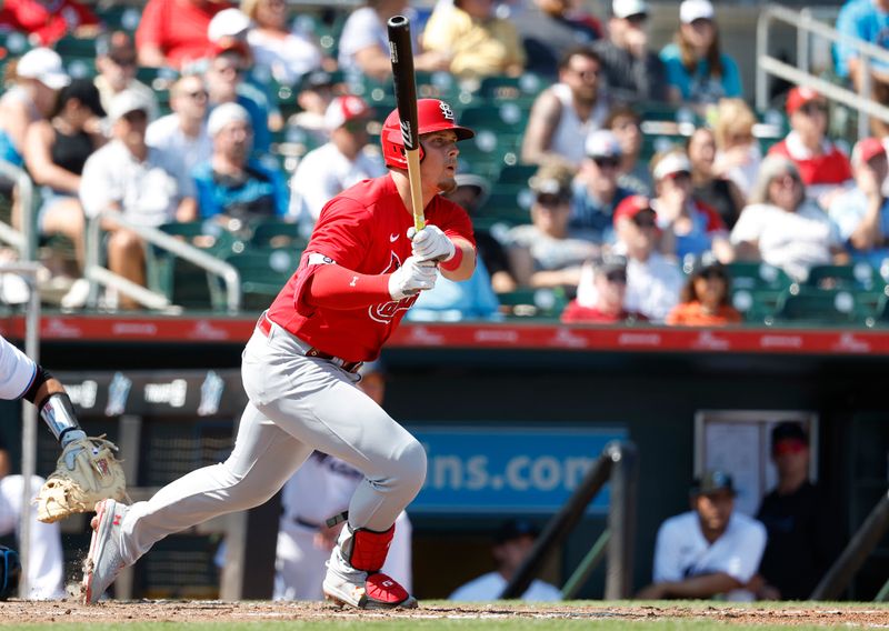 Feb 26, 2023; Jupiter, Florida, USA; St. Louis Cardinals Nolan Gorman (16) singles in the third inning against the Miami Marlins at Roger Dean Stadium. Mandatory Credit: Rhona Wise-USA TODAY Sports