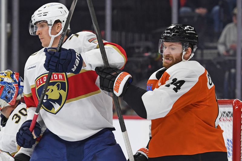 Dec 5, 2024; Philadelphia, Pennsylvania, USA; Florida Panthers defenseman Niko Mikkola (77) and Philadelphia Flyers center Sean Couturier (14) battle for position during the first period at Wells Fargo Center. Mandatory Credit: Eric Hartline-Imagn Images